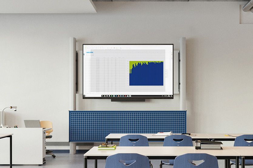 Seminar room with a display and a blue chalkboard in front of VS desks and JUMPER chairs