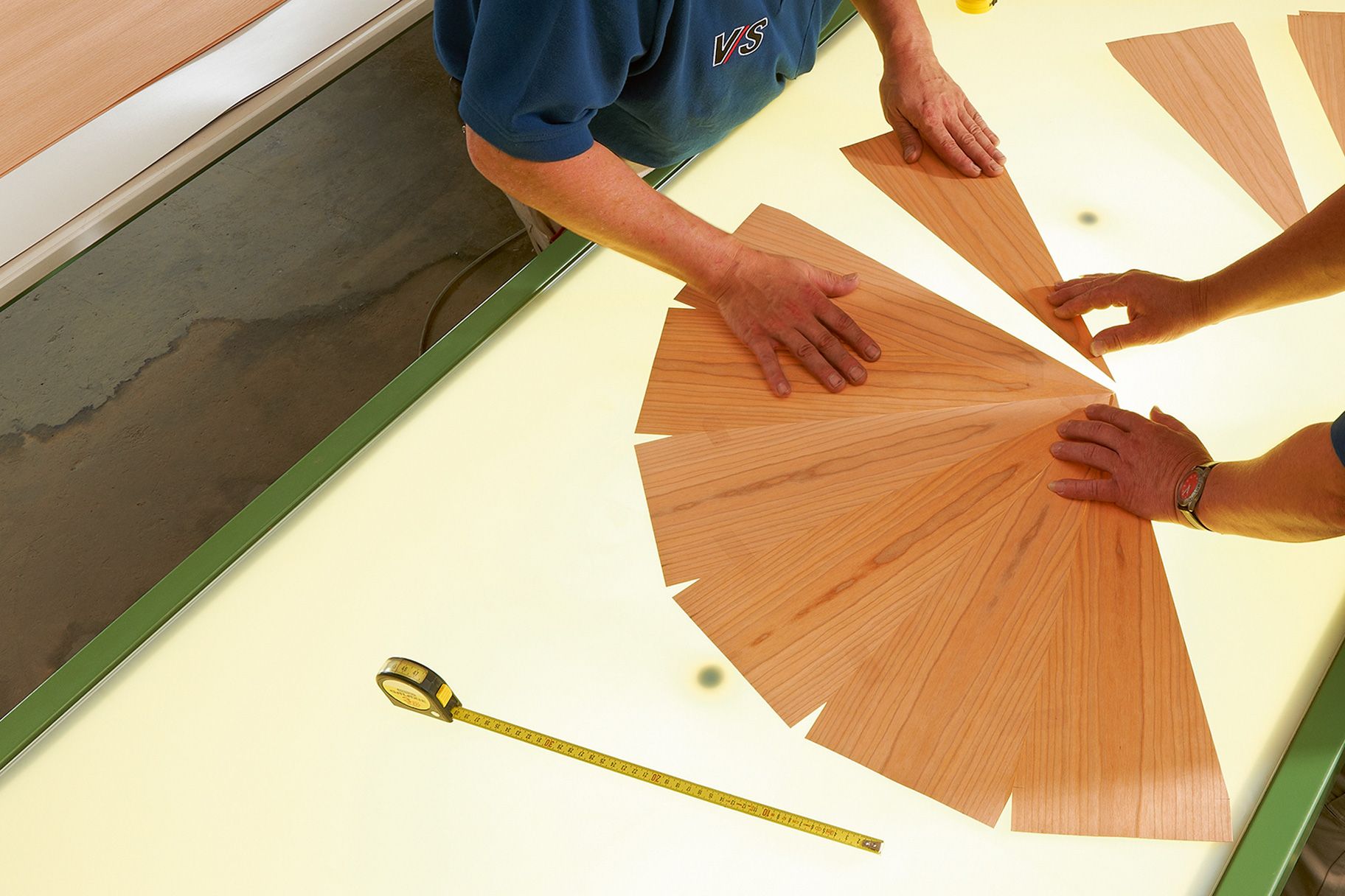 VS employees lay pieces of veneer together on a table