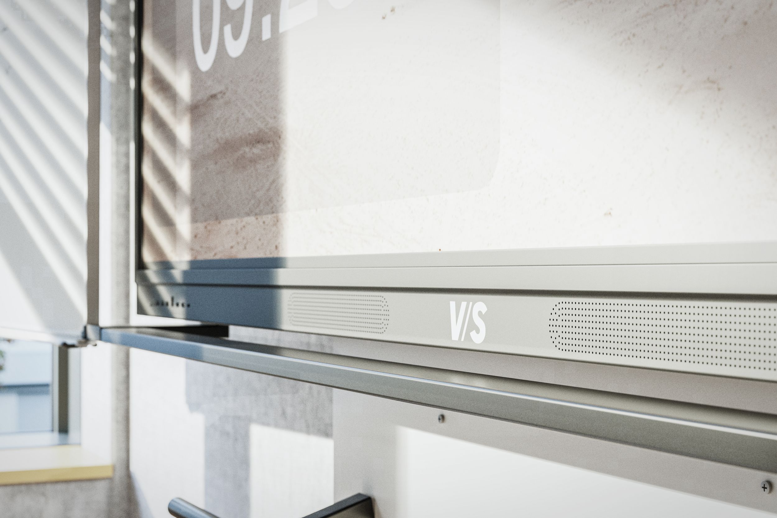 Close-up of the VS DUAL display's built-in speakers, with the VS logo on the bottom of the frame.