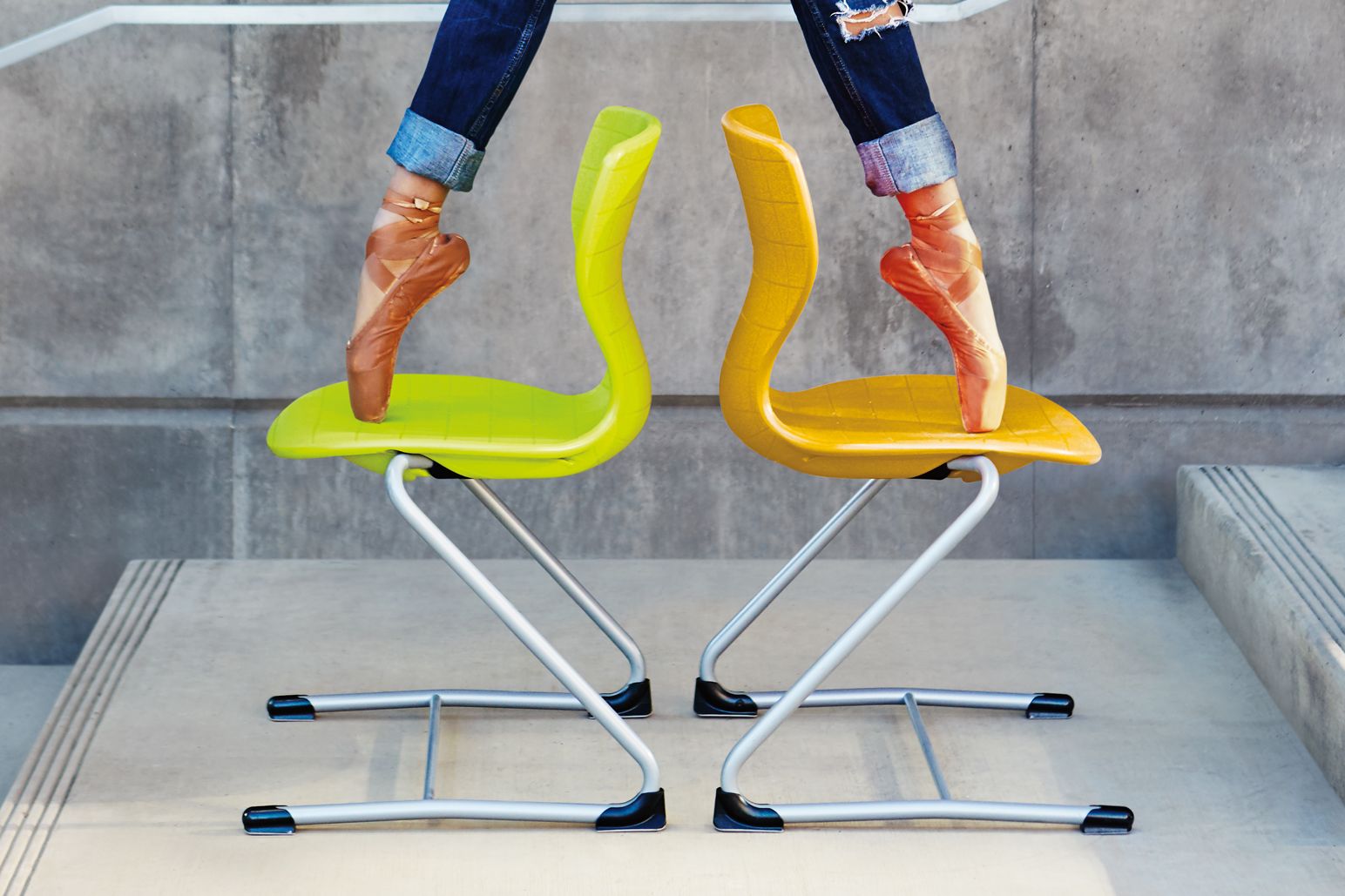 A ballet dancer balances on two Panto-Swing chairs by VS