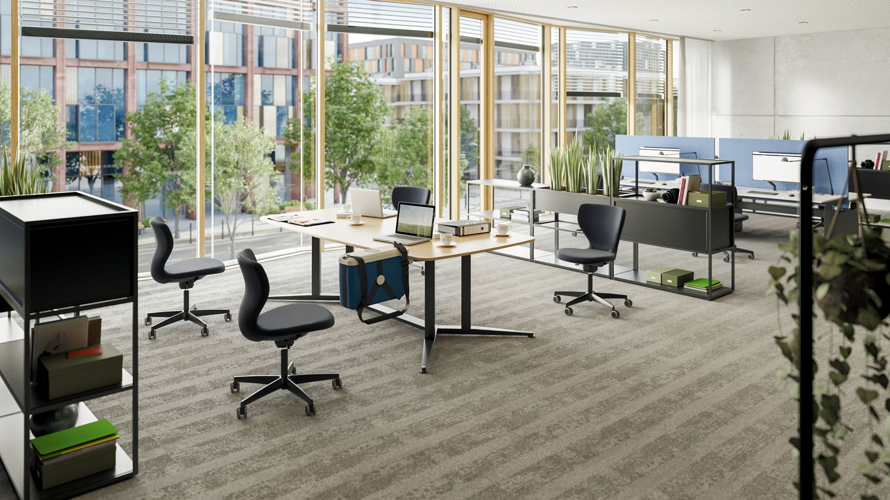 A meeting area with a large table, black PantoMove swivel chairs, and open shelves with planters, set within a modern office environment.