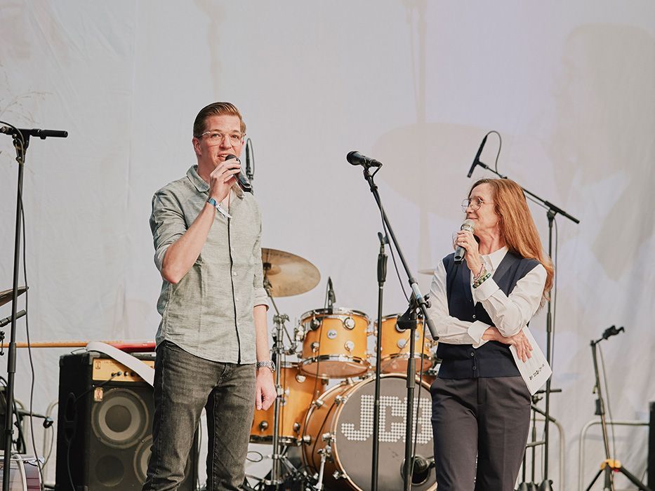Managing Director Philipp Müller stands on the stage next to the presenter and welcomes the guests to the 125th anniversary celebrations of VS.