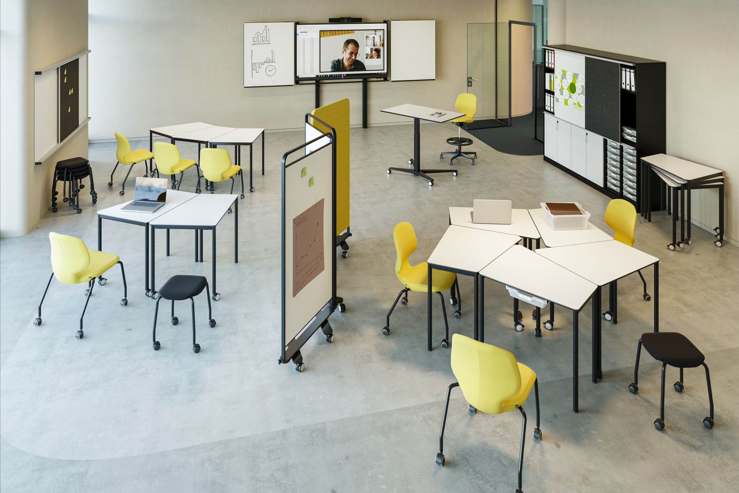 A Creative Space featuring flexibly arranged Tano tables, yellow JUMPER chairs on castors, stools, and a display unit with chalkboard surfaces; storage space with sliding panels complements the work area.