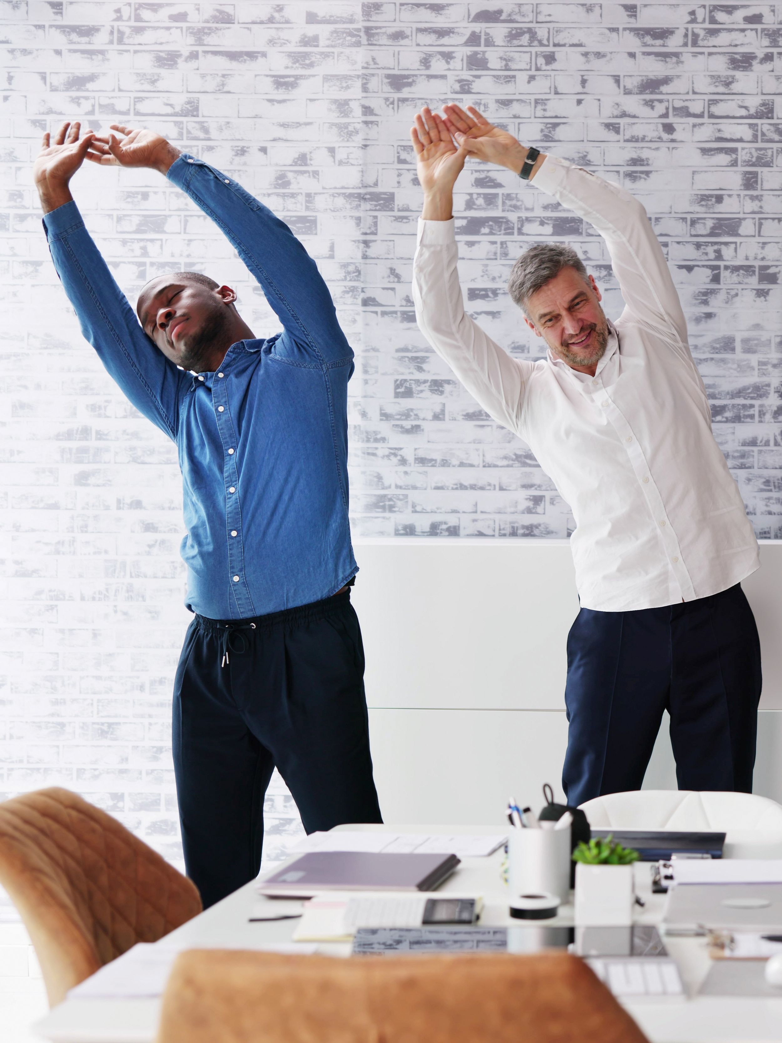 Three people stretch during sports exercises for employees