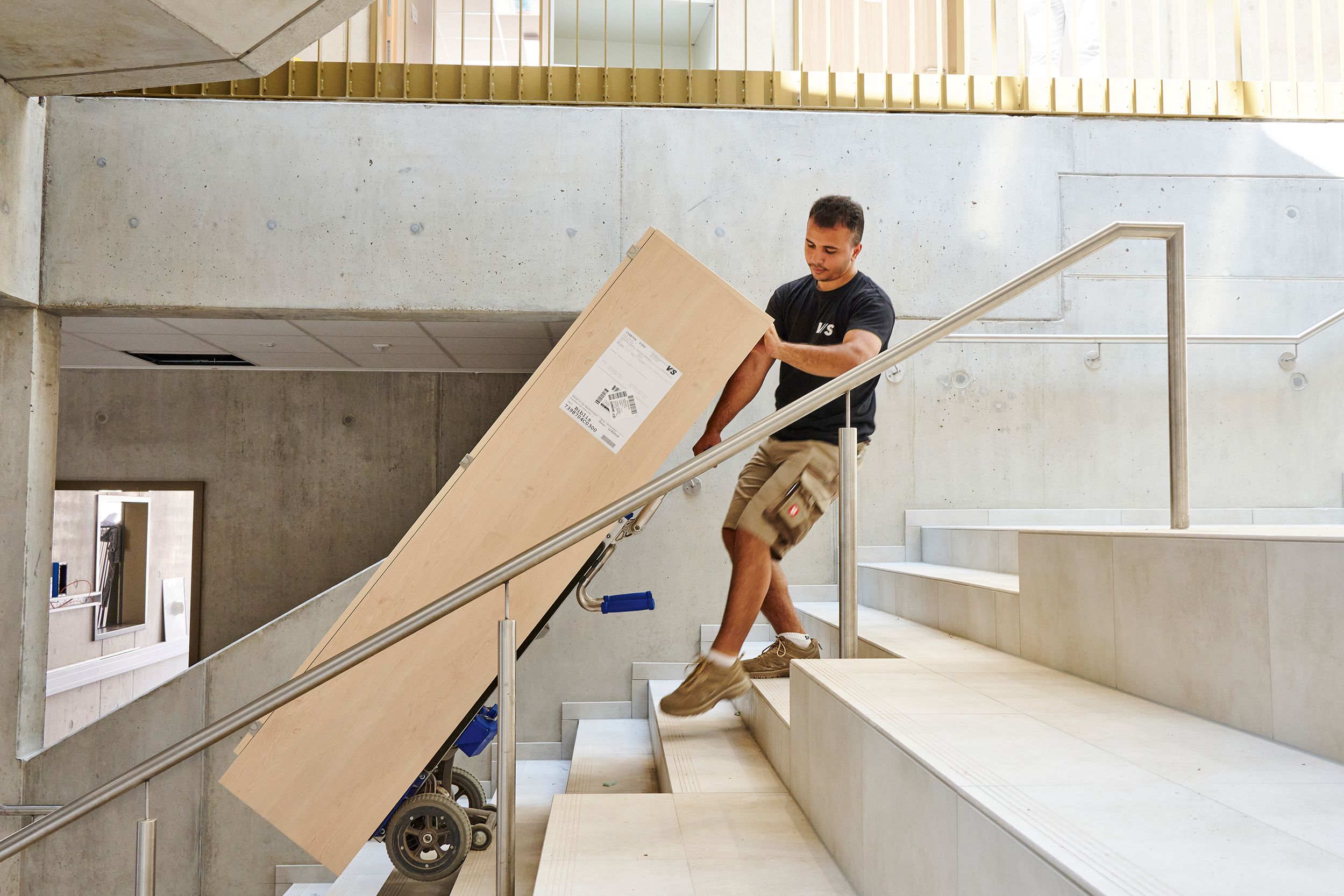 A VS fitter with a loaded handcart in a stairwell