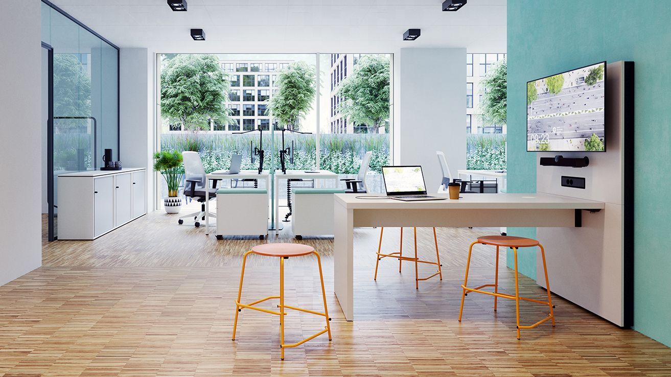 A counter with an interactive display provides space for digital collaboration in an office.