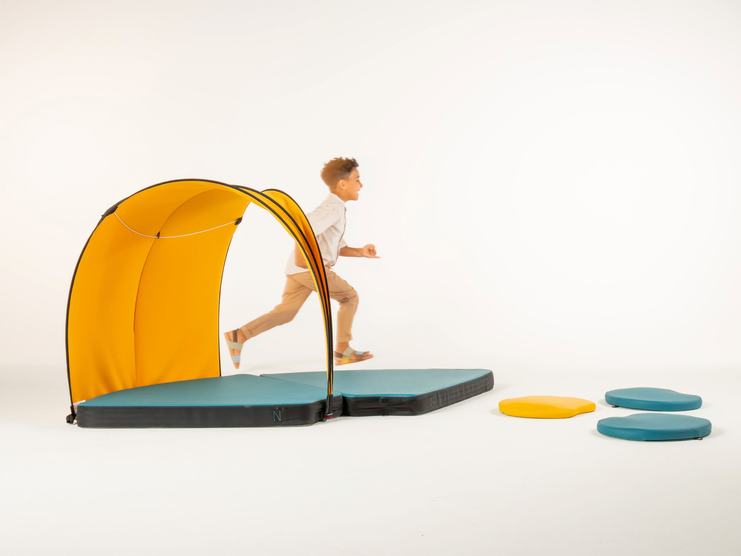 Boy in motion next to tent and padded mats from the VS FloorFriends range