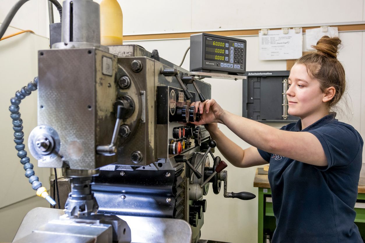 A young employee of VS operates a machine