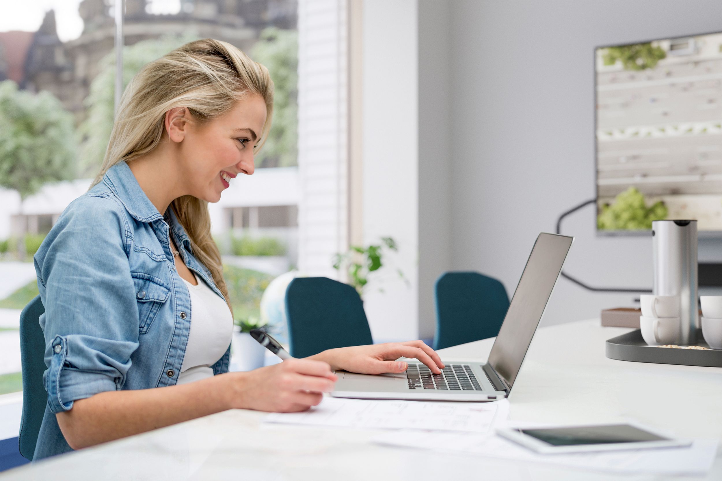 Woman looks at laptop and smiles