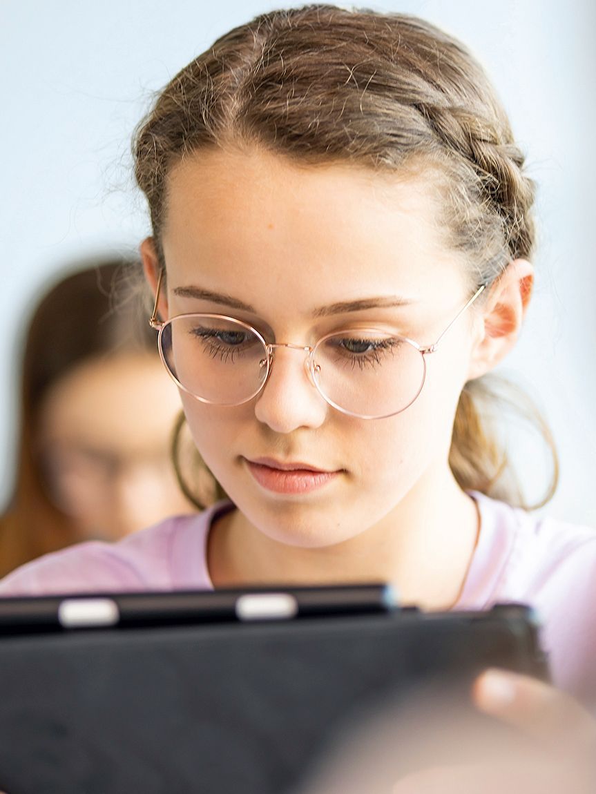 A girl is looking at a tablet