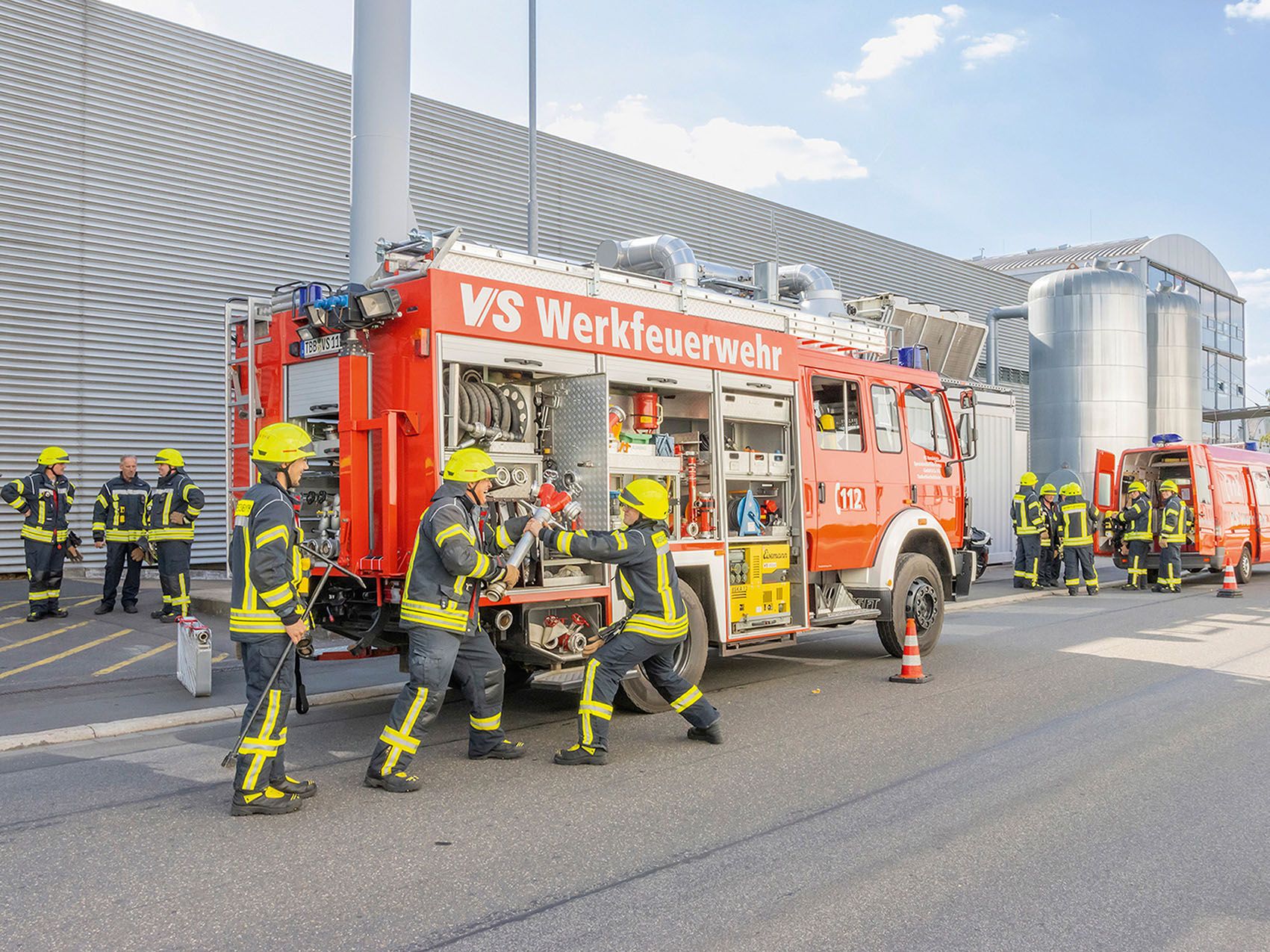 Pompiers de l'usine VS devant un camion de pompiers