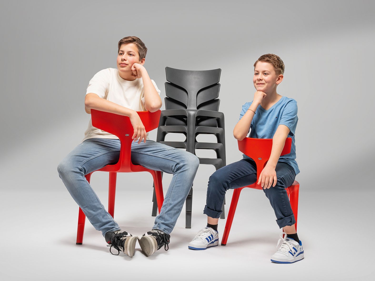 Two boys are sitting on different sized VS chairs Stakki