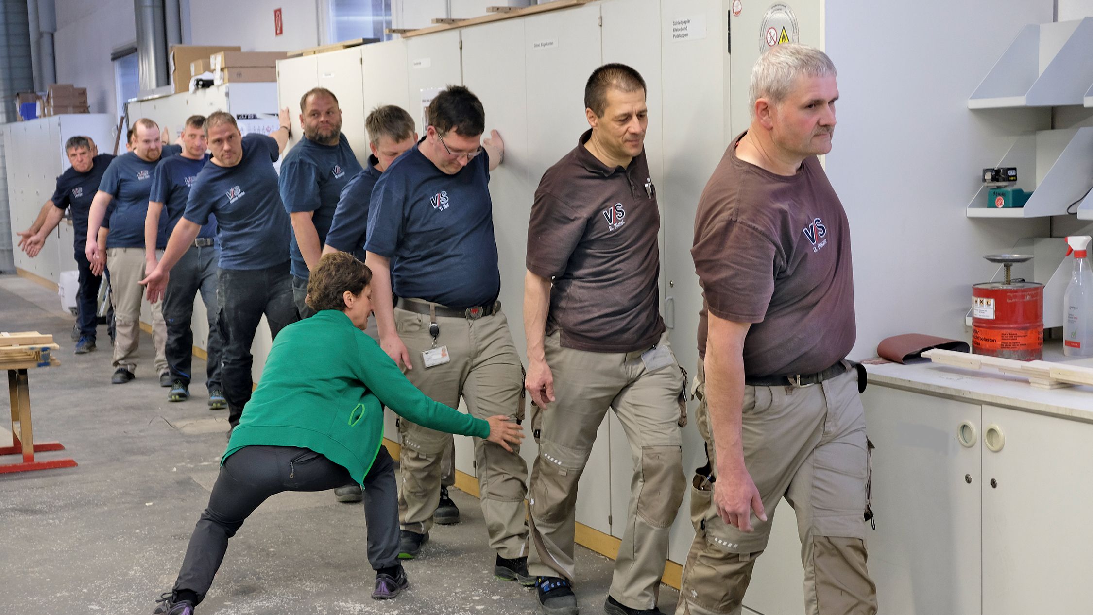 VS employees do gymnastics during their break with guidance from an AOK employee.