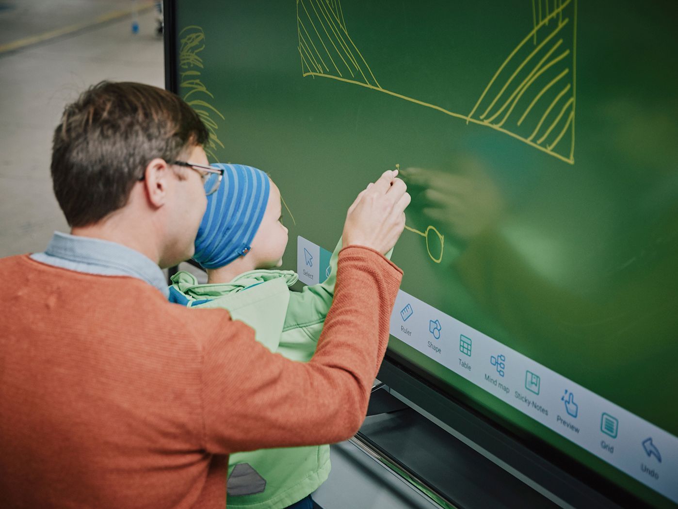 A father draws with his child on an interactive display by VS