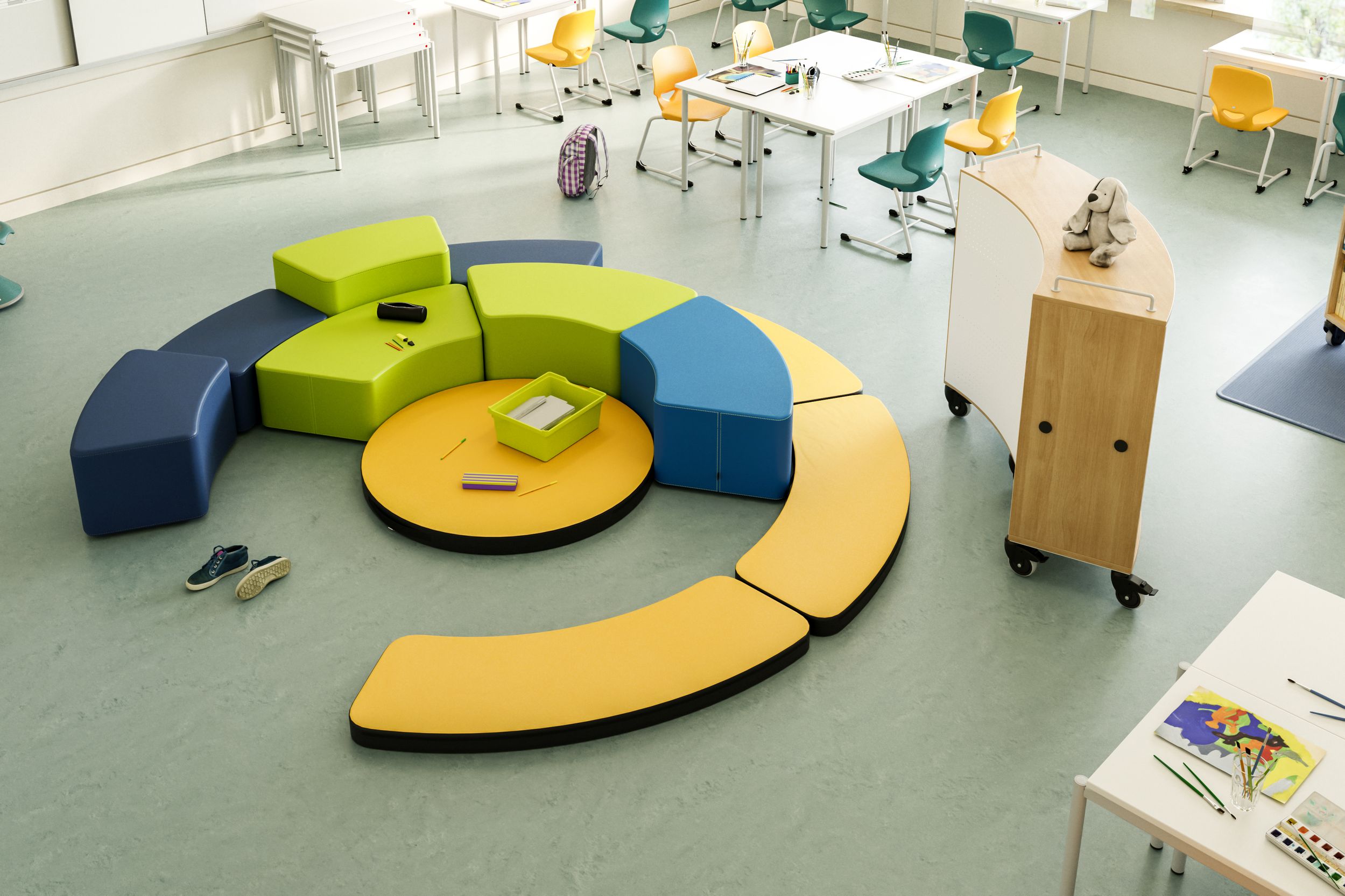 A flexible elementary school learning space featuring colorful FloorFriends cushioning elements arranged in a circle, individual desks, and cantilever chairs from VS