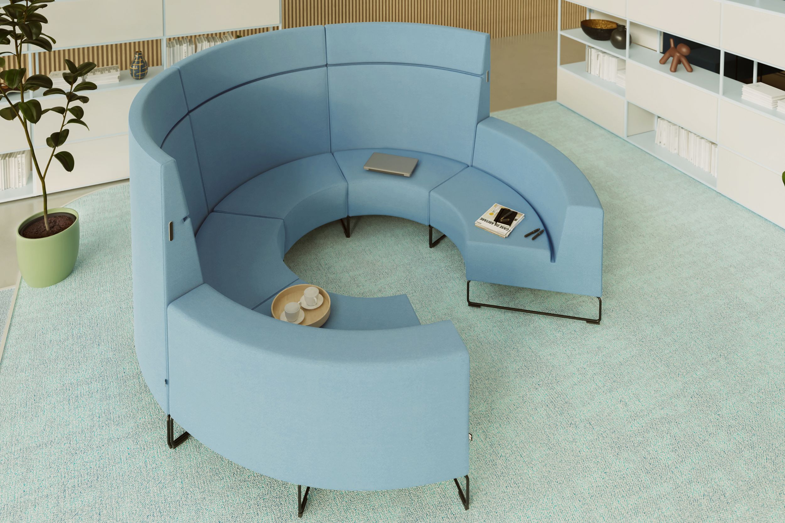 Canapé de salon de forme arrondie, de couleur bleu clair, dans un bureau